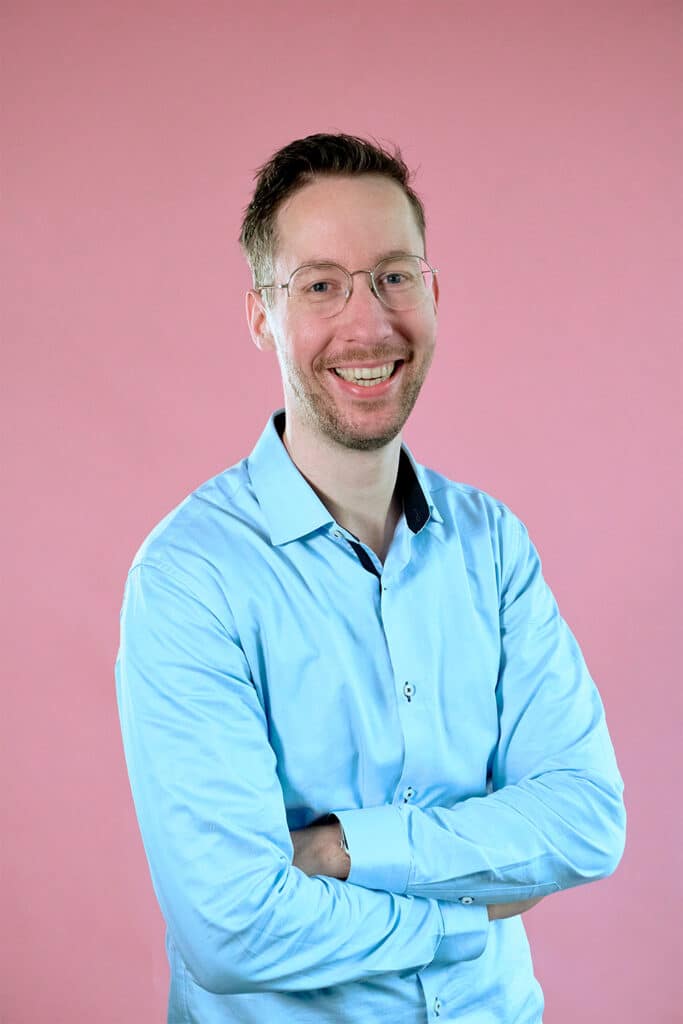 Joris op een roze achtergrond met een blauw overhemd