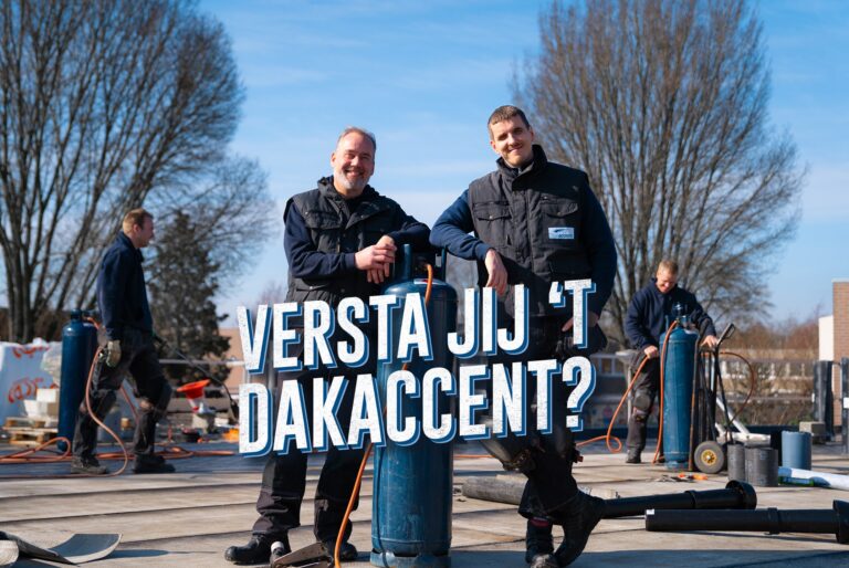Een foto van twee mannen in de buitenlucht op een dak. Ze staan nonchalant tegen een soort tankje aan te leunen. In het midden van de foto staat 'Versta jij 't dakaccent?'