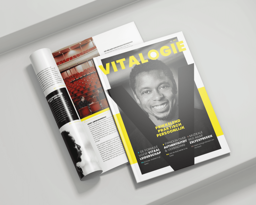 Een gedrukt exemplaar van het magazine "VITALOGIE" ligt opengeslagen op een witte ondergrond, met daarnaast een dichte editie waarop een lachende man in zwart-wit staat afgebeeld. De cover heeft gele accenten en grote typografie met woorden als "Prikkelend, Praktisch, Persoonlijk" en onderwerpen zoals vitaal leiderschap, authenticiteit en zelfexpressie.