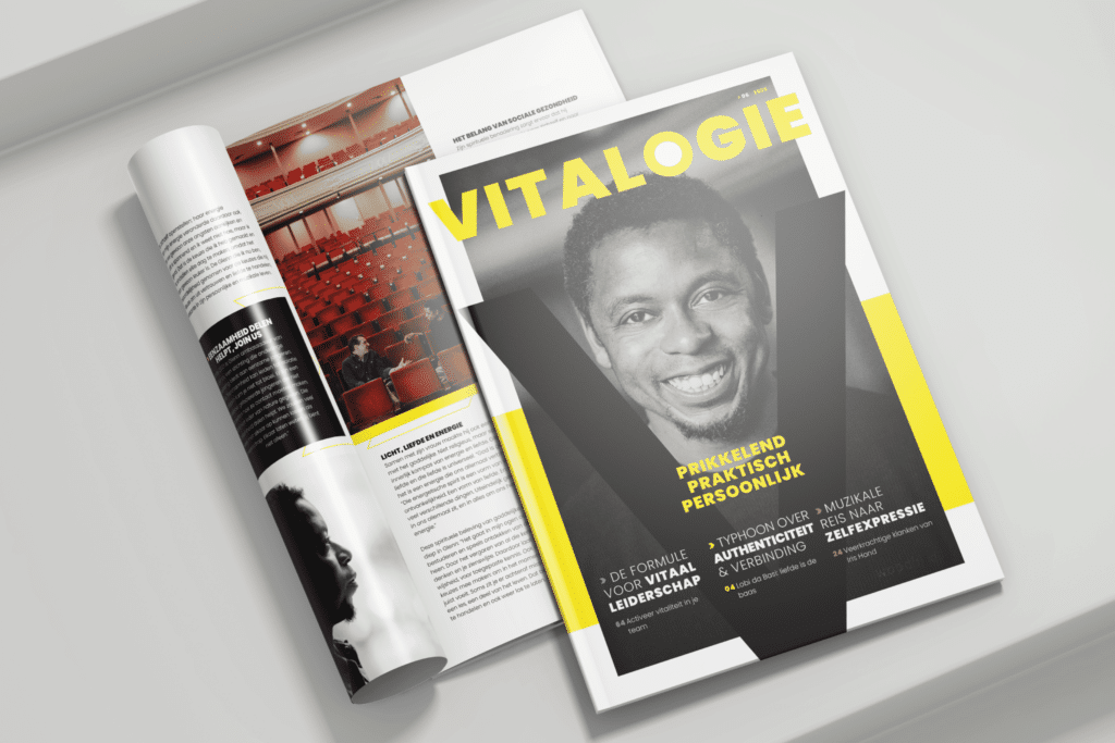 Een gedrukt exemplaar van het magazine "VITALOGIE" ligt opengeslagen op een witte ondergrond, met daarnaast een dichte editie waarop een lachende man in zwart-wit staat afgebeeld. De cover heeft gele accenten en grote typografie met woorden als "Prikkelend, Praktisch, Persoonlijk" en onderwerpen zoals vitaal leiderschap, authenticiteit en zelfexpressie.