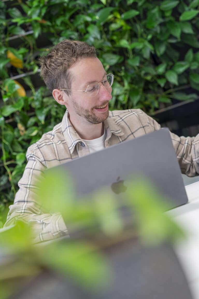 Man met baard en bril achter een laptop