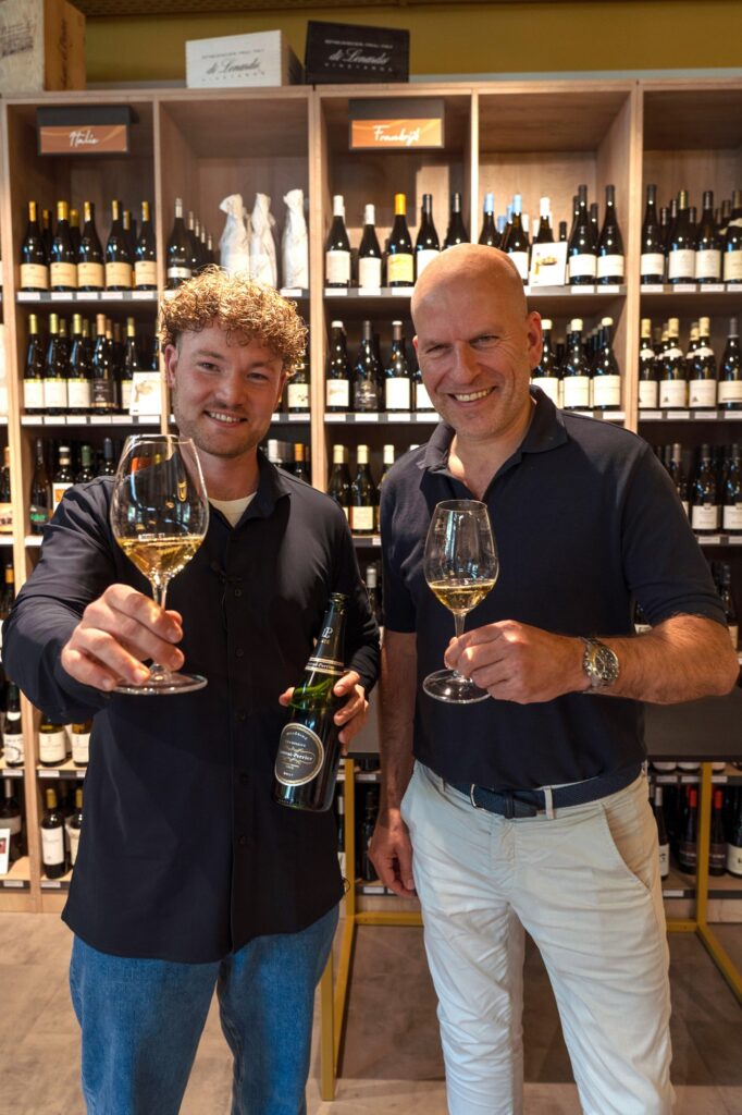Twee OONIVOO-teamleden met wijn in de winkel.
